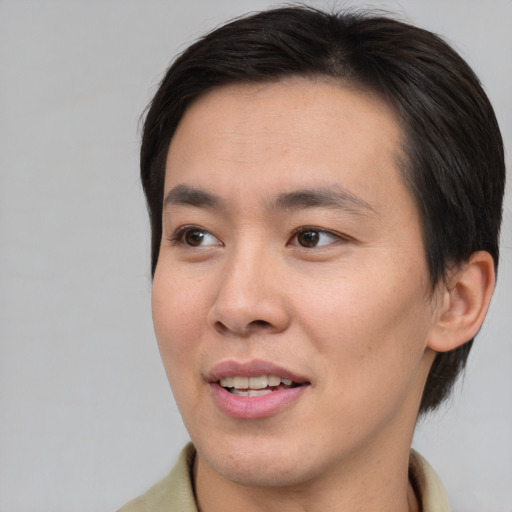 Joyful asian young-adult male with short  brown hair and brown eyes