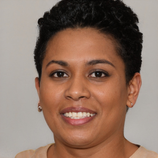 Joyful black young-adult female with short  brown hair and brown eyes