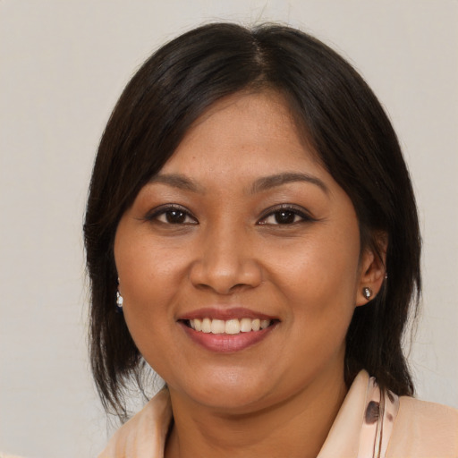 Joyful latino young-adult female with medium  brown hair and brown eyes