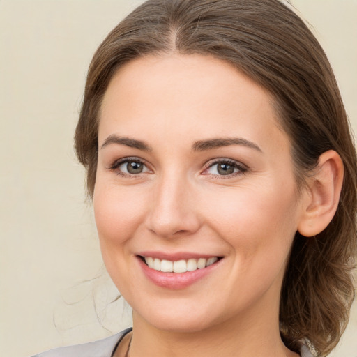 Joyful white young-adult female with medium  brown hair and grey eyes