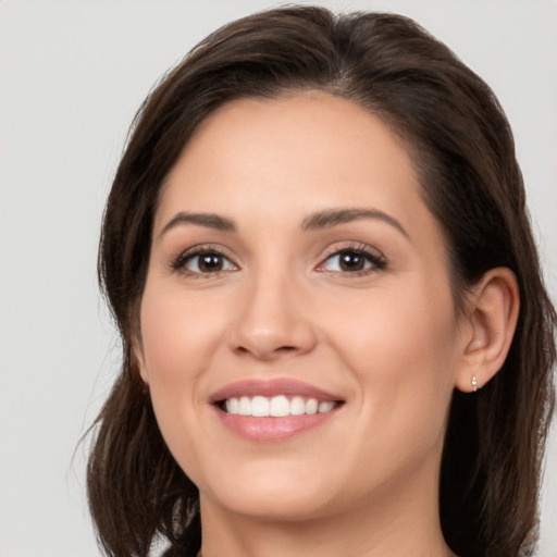 Joyful white young-adult female with long  brown hair and brown eyes