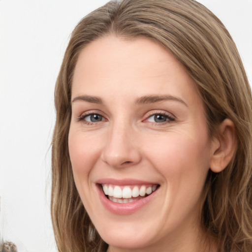 Joyful white young-adult female with long  brown hair and green eyes