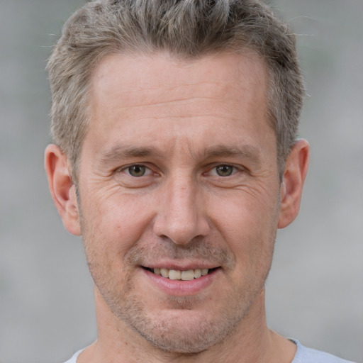 Joyful white adult male with short  brown hair and grey eyes