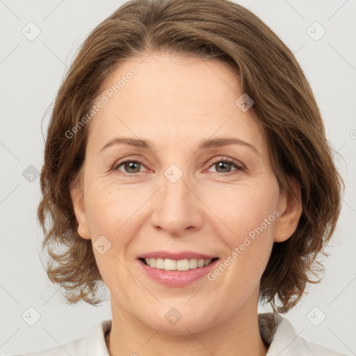 Joyful white adult female with medium  brown hair and grey eyes