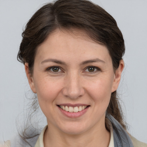 Joyful white young-adult female with medium  brown hair and grey eyes