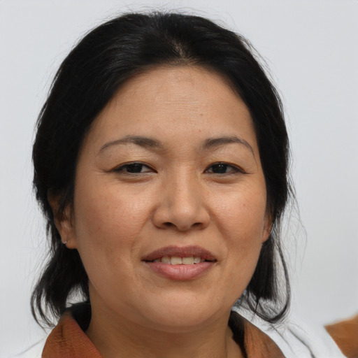 Joyful asian adult female with medium  brown hair and brown eyes