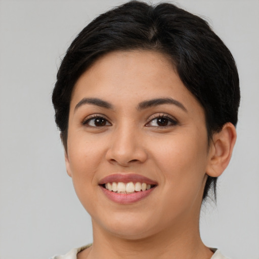 Joyful latino young-adult female with medium  brown hair and brown eyes