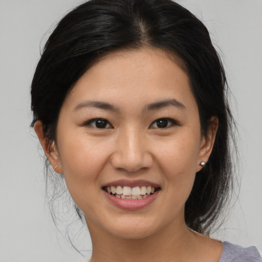 Joyful asian young-adult female with medium  brown hair and brown eyes