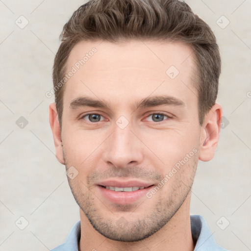 Joyful white young-adult male with short  brown hair and grey eyes