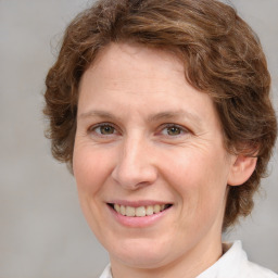 Joyful white adult female with medium  brown hair and green eyes