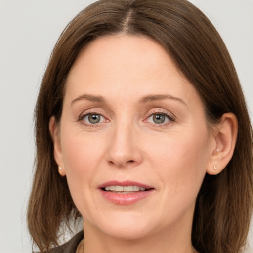 Joyful white adult female with long  brown hair and grey eyes