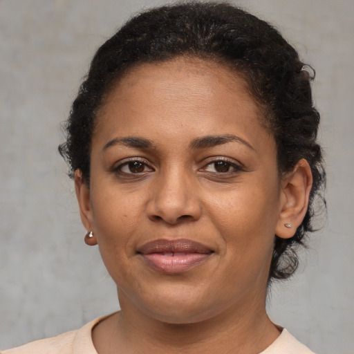 Joyful black young-adult female with short  brown hair and brown eyes