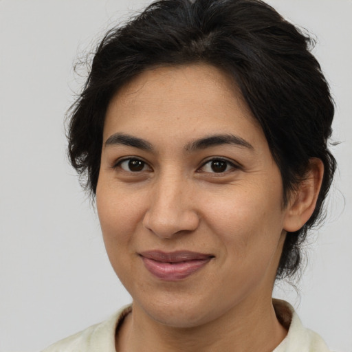 Joyful latino adult female with medium  brown hair and brown eyes