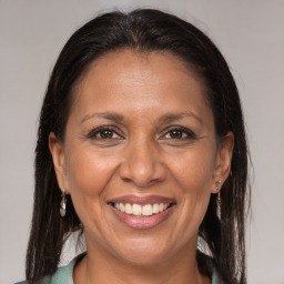 Joyful latino adult female with medium  brown hair and brown eyes