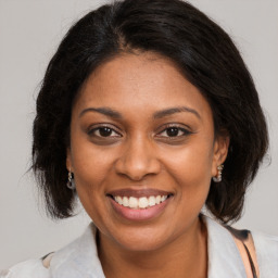 Joyful black young-adult female with medium  brown hair and brown eyes