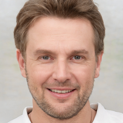 Joyful white adult male with short  brown hair and grey eyes