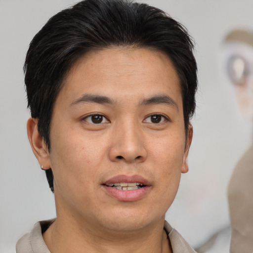 Joyful asian young-adult male with short  brown hair and brown eyes