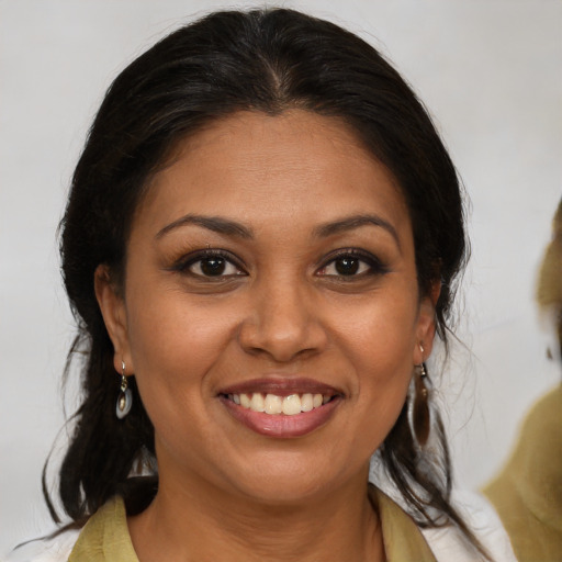 Joyful latino adult female with medium  brown hair and brown eyes