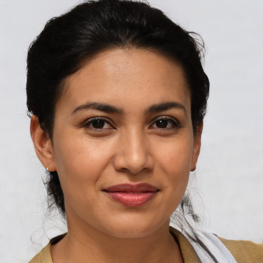 Joyful latino young-adult female with medium  brown hair and brown eyes