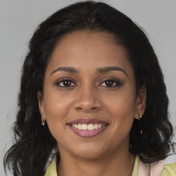 Joyful black young-adult female with long  brown hair and brown eyes