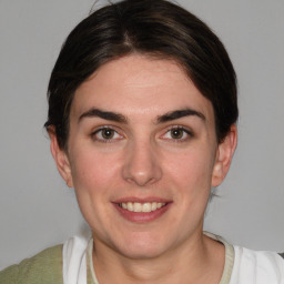 Joyful white young-adult female with medium  brown hair and grey eyes