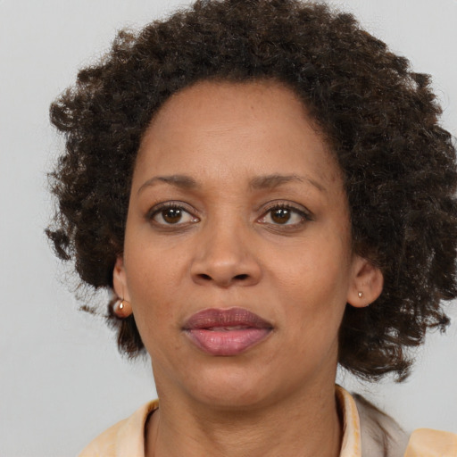 Joyful black adult female with medium  brown hair and brown eyes