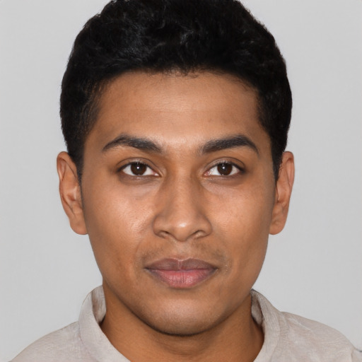 Joyful latino young-adult male with short  black hair and brown eyes