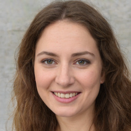 Joyful white young-adult female with long  brown hair and green eyes