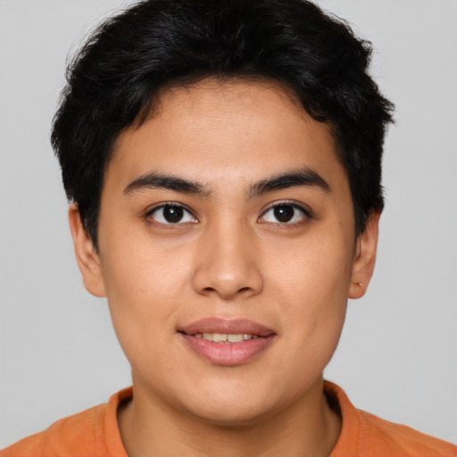 Joyful latino young-adult male with short  brown hair and brown eyes