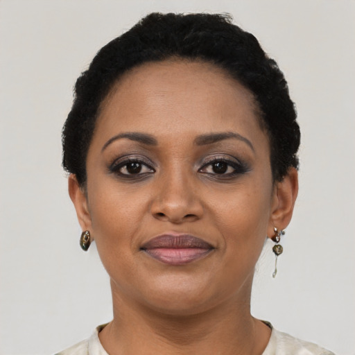 Joyful black young-adult female with short  black hair and brown eyes