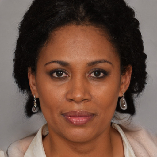 Joyful black adult female with long  brown hair and brown eyes