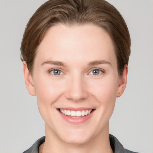 Joyful white young-adult female with short  brown hair and grey eyes