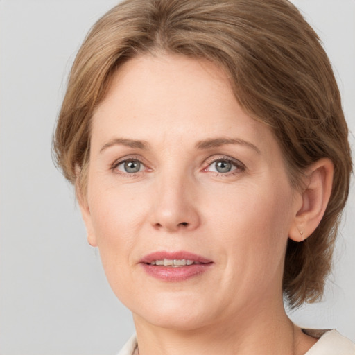 Joyful white adult female with medium  brown hair and grey eyes