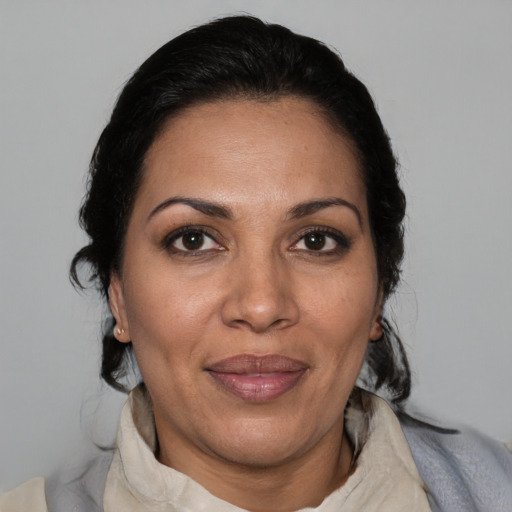 Joyful latino adult female with medium  brown hair and brown eyes