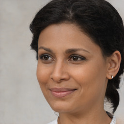 Joyful black adult female with medium  brown hair and brown eyes