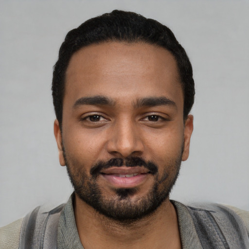 Joyful black young-adult male with short  black hair and brown eyes