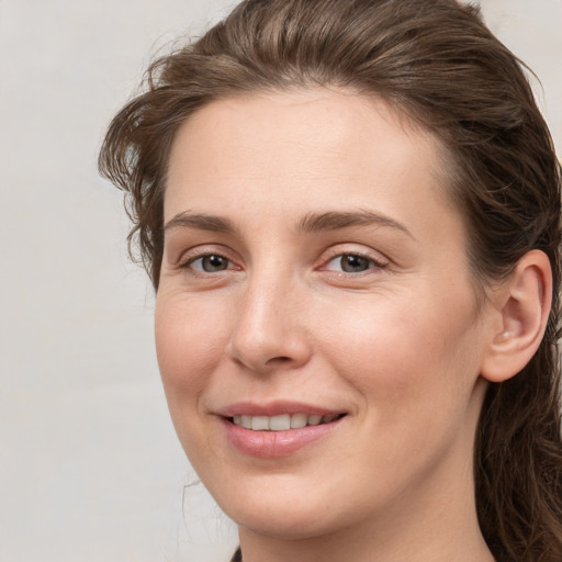 Joyful white young-adult female with medium  brown hair and grey eyes