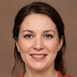 Joyful white adult female with medium  brown hair and grey eyes