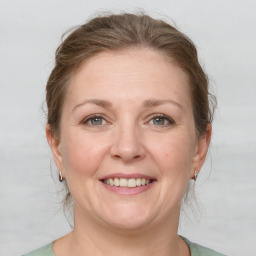 Joyful white adult female with medium  brown hair and grey eyes