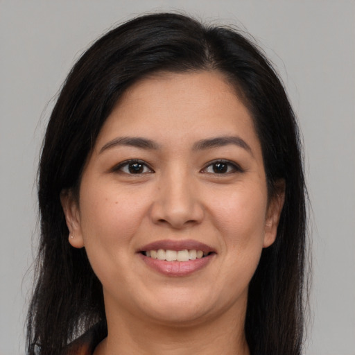 Joyful latino young-adult female with long  brown hair and brown eyes