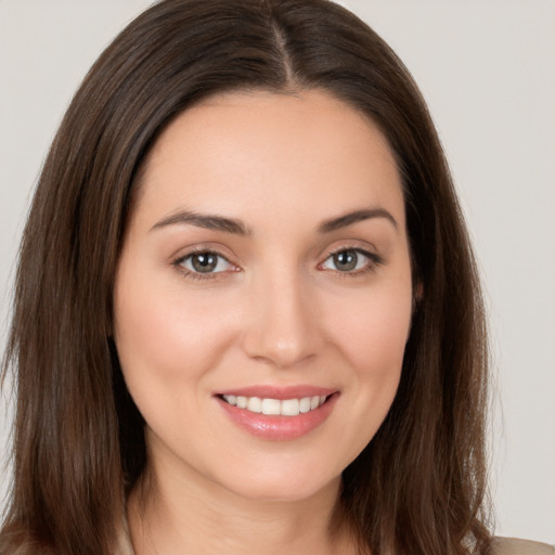 Joyful white young-adult female with long  brown hair and brown eyes