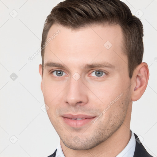 Joyful white young-adult male with short  brown hair and grey eyes