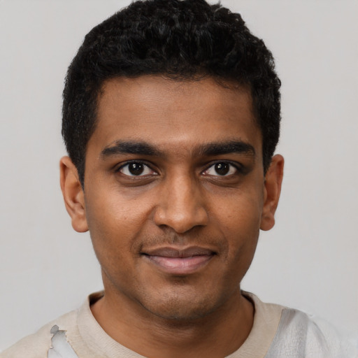 Joyful black young-adult male with short  black hair and brown eyes