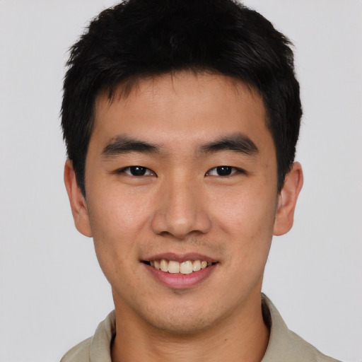 Joyful asian young-adult male with short  black hair and brown eyes