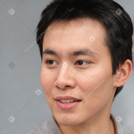 Joyful asian young-adult male with short  brown hair and brown eyes