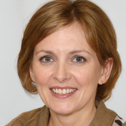 Joyful white adult female with medium  brown hair and blue eyes