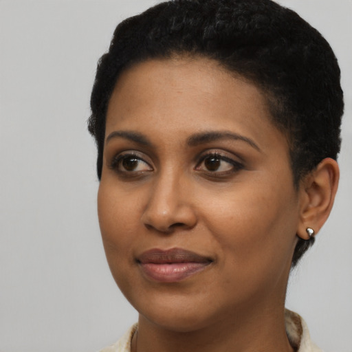 Joyful black young-adult female with short  black hair and brown eyes