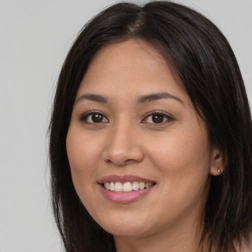 Joyful latino young-adult female with long  brown hair and brown eyes