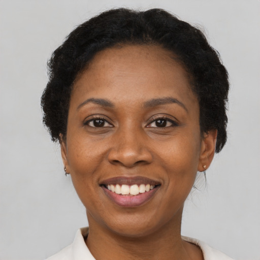 Joyful black adult female with short  black hair and brown eyes