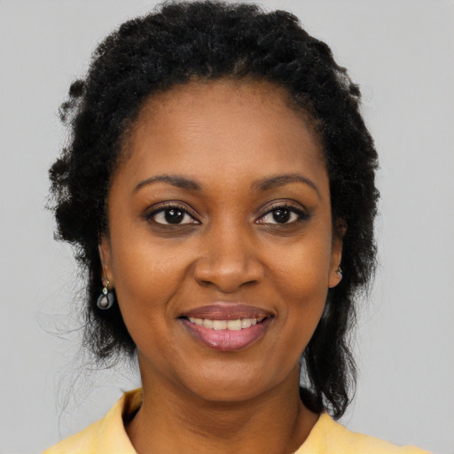Joyful black young-adult female with short  black hair and brown eyes